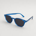 Blue frame sunglasses with dark lenses resting on a wooden table